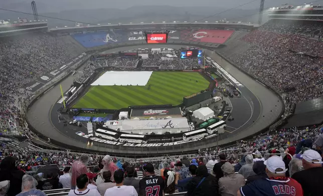 The field is covered up during a rain delay at the MLB Speedway Classic baseball game between the Atlanta Braves and the Cincinnati Reds at Bristol Motor Speedway in Bristol, Tenn., Saturday, Aug. 2, 2025. (AP Photo/George Walker IV)