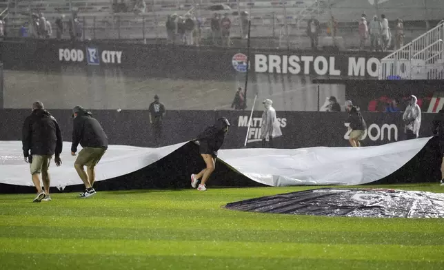 Member of the ground cover the field during a rain delay in the first inning of the MLB Speedway Classic baseball game at Bristol Motor Speedway in Bristol, Tenn., Saturday, Aug. 2, 2025. (AP Photo/George Walker IV)