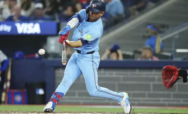 Toronto Blue Jays second base Andres Gimenez (0) hits a single against the Chicago Cubs during sixth inning MLB baseball action in Toronto on Wednesday, August 13, 2025. (Nathan Denette/The Canadian Press via AP)