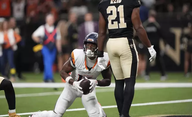 Denver Broncos wide receiver Courtland Sutton, left, reacts after catching a pass for a touchdown as New Orleans Saints safety Justin Reid looks on in the first half of an NFL preseason football game Saturday, Aug. 23, 2025, in New Orleans. (AP Photo/Gerlad Herbert)