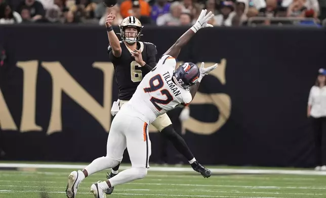 New Orleans Saints quarterback Tyler Shough, back, throws a pass as Denver Broncos linebacker Dondrea Tillman pursues in the first half of an NFL preseason football game Saturday, Aug. 23, 2025, in New Orleans. (AP Photo/Gerald Herbert)