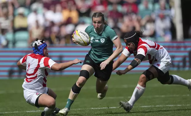 Ireland's Eve Higgins, evades a tackle during the group C match between Ireland and Japan of the 2025 Women's Rugby World Cup, in Northampton, England, Sunday, Aug. 24, 2025. (AP Photo/Dave Shopland)