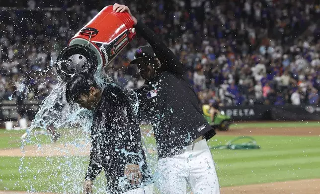 New York Mets' Jonah Tong, left, is doused with water after defeating the Miami Marlins during a baseball game Friday, Aug. 29, 2025, in New York. (AP Photo/Pamela Smith)