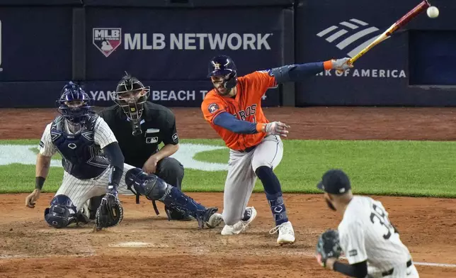Houston Astros' Carlos Correa (1) hits an RBI single during the 10th inning of a baseball game against the New York Yankees Friday, Aug. 8, 2025, in New York. (AP Photo/Frank Franklin II)