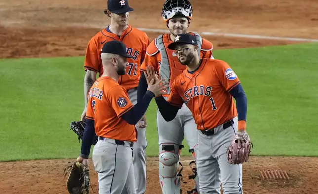 Houston Astros' Carlos Correa (1) celebrates with Christian Walker (8) after a baseball game against the New York Yankees Friday, Aug. 8, 2025, in New York. (AP Photo/Frank Franklin II)