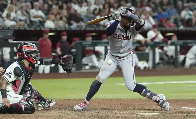 Cleveland Guardians' Angel Martínez, right, backs off an inside pitch as Arizona Diamondbacks catcher Jose Herrera, left, reaches for the ball during the eighth inning of a baseball game Tuesday, Aug. 19, 2025, in Phoenix. (AP Photo/Ross D. Franklin)