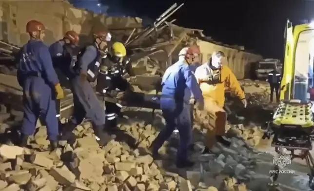 In this photo, released by the Russian Emergency Ministry Press Service on Saturday, Aug. 16, 2025, Emergency Ministry employees carry a wounded person through debris of an industrial plant after a fire at the facility in the Shilovsky District, Ryazan region, around 250 kilometers (155 miles) southeast of Moscow, Russia. (Russian Emergency Ministry Press Service via AP)