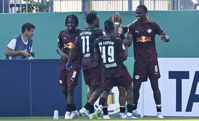 Leipzig's Ezechiel Banzuzi, right, celebrates after scoring his side's third goal during the German soccer cup first round match between SV Sandhausen and RB Leipzig in Sandhausen, Germany, Saturday, Aug. 16, 2025. (Uwe Anspach/dpa via AP)