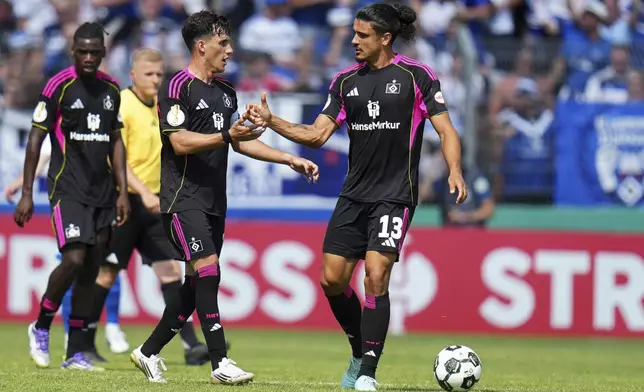 Hamburg's Guilherme Ramos, right, celebrates with his teammates after scoring his side's first goal during the German soccer cup first round match between FK Pirmasens and Hamburger SV in Pirmasens, Germany, Saturday, Aug. 16, 2025. (Thomas Frey/dpa via AP)
