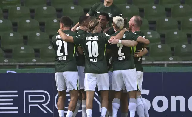 Wolfsburg's players celebrate the opening goal during the German soccer cup first round match between SV Hemelingen and VfL Wolfsburg in Bremen, Germany, Saturday, Aug 16, 2025. (Carmen Jaspersen/dpa via AP)