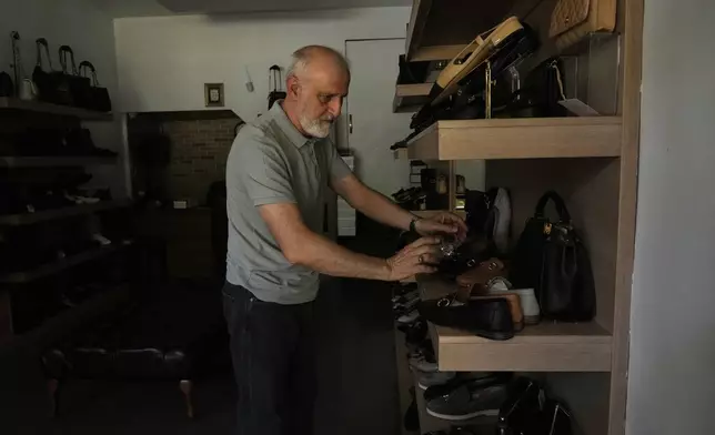 A shopkeeper arranges shoes during power outage in Tehran, Iran, Tuesday, Aug. 5, 2025. (AP Photo/Vahid Salemi)