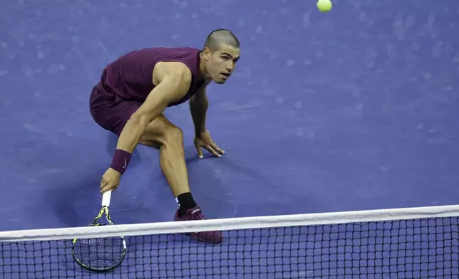 Carlos Alcaraz, of Spain, returns a shot to Reilly Opelka, of the United States, during the first round of the U.S. Open tennis championships, Monday, Aug. 25, 2025, in New York. (AP Photo/Adam Hunger)