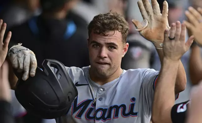 Miami Marlins' Jakob Marsee is congratulated in the dugout after hitting a two-run home run off Cleveland Guardians relief pitcher Matt Festa during the fifth inning of a baseball game, Wednesday, Aug. 13, 2025, in Cleveland. (AP Photo/David Dermer)