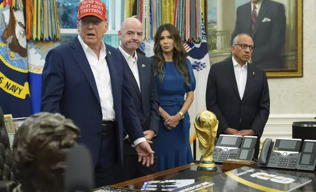 President Donald Trump, from left, speaks as FIFA President Gianni Infantino, Homeland Security Secretary Kristi Noem and Carlos Cordeiro listen in the Oval Office of the White House, Friday, Aug. 22, 2025, in Washington. (AP Photo/Jacquelyn Martin)