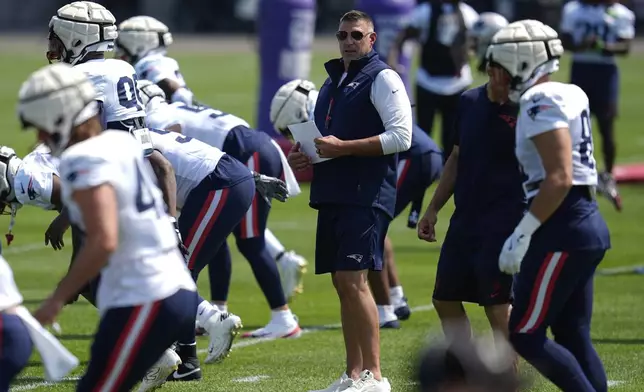 New England Patriots head coach Mike Vrabel, middle, stands on the field during a joint NFL football training camp with the Minnesota Vikings, Wednesday, Aug. 13, 2025, in Eagan, Minn. (AP Photo/Abbie Parr)
