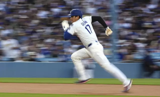 Los Angeles Dodgers' Shohei Ohtani attempts the steal third before being called back for a foul ball during the first inning of a baseball game against the Toronto Blue Jays, Friday, Aug. 8, 2025, in Los Angeles. (AP Photo/Mark J. Terrill)