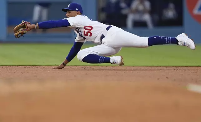 Los Angeles Dodgers shortstop Mookie Betts makes a catch on a line drive hit by Toronto Blue Jays' Myles Straw before doubling up Ty France at second during the second inning of a baseball game Friday, Aug. 8, 2025, in Los Angeles. (AP Photo/Mark J. Terrill)
