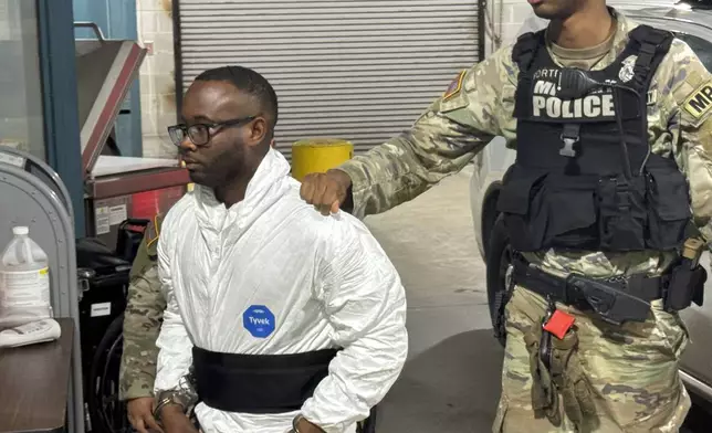 Sgt. Quornelius Radford, a suspect in the shooting of five soldiers at Fort Stewart, is escorted by military police into a booking room at the Liberty County Jail in Hinesville, Ga., Wednesday, Aug. 6, 2025. (AP Photo/Lewis M. Levine)