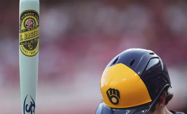Milwaukee Brewers' Christian Yelich stands in the on-deck circle, holding a custom bat for Players' Weekend, in the first inning of a baseball game against the Cincinnati Reds, Friday, Aug. 15, 2025, in Cincinnati. (AP Photo/Kareem Elgazzar)
