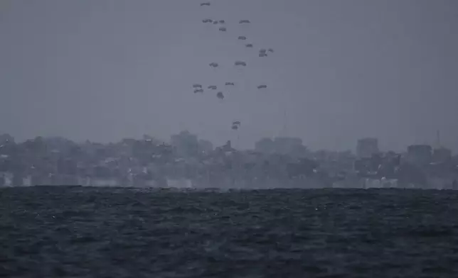 Humanitarian aid is airdropped to Palestinians over the Gaza Strip, as seen from the Mediterranean Sea off the coast of Ashkelon, southern Israel, Thursday, Aug. 7, 2025. (AP Photo/Leo Correa)