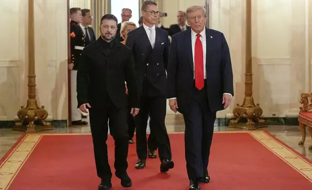 Ukraine's President Volodymyr Zelenskyy, from left, Finland's President Alexander Stubb and President Donald Trump walk through the Cross Hall of the White House, Monday, Aug. 18, 2025, in Washington. (AP Photo/Alex Brandon)