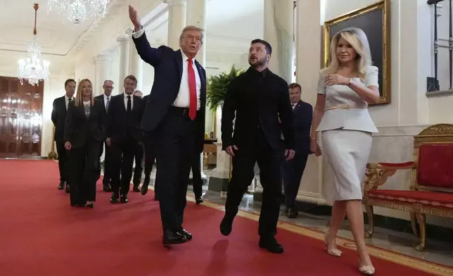 Monica Crowley, White House chief of protocol, from right, Ukrainian President Volodymyr Zelenskyy, President Donald Trump, France's President Emmanuel Macron, Germany's Chancellor Friedrich Merz, Italy's Prime Minister Giorgia Meloni and NATO Secretary General Mark Rutte walk through the Cross Hall of the White House, Monday, Aug. 18, 2025, in Washington. (AP Photo/Alex Brandon)