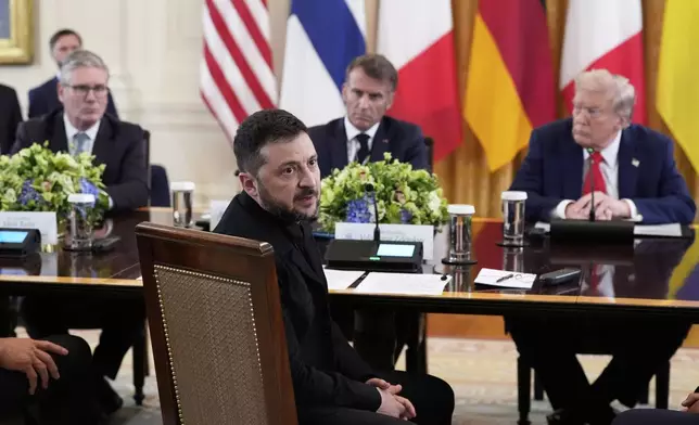Ukraine's President Volodymyr Zelenskyy speaks as British Prime Minister Keir Starmer, seated from background left, France's President Emmanuel Macron and President Donald Trump listen during a meeting in the East Room of the White House, Monday, Aug. 18, 2025, in Washington. (AP Photo/Alex Brandon)