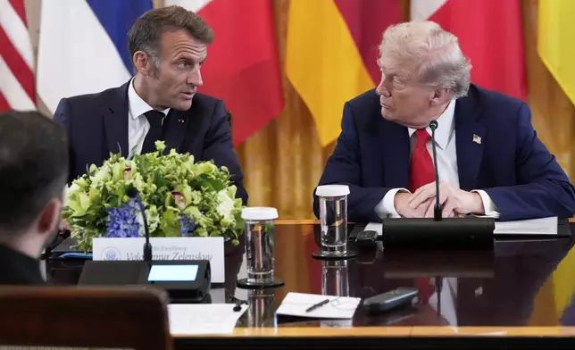 France's President Emmanuel Macron, left, and President Donald Trump speak during a meeting in the East Room of the White House with Ukrainian President Volodymyr Zelenskyy, Monday, Aug. 18, 2025, in Washington. (AP Photo/Alex Brandon)