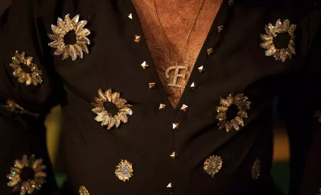 Tudor Lakatos, who goes by the stage name Elvis Rromano, takes a break half way through his performance at the Terasa Florilor restaurant in Bucharest, Romania, Friday, June 20, 2025. (AP Photo/Vadim Ghirda)