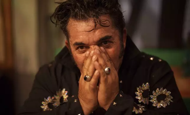 Tudor Lakatos, who goes by the stage name Elvis Rromano, takes a break half way through his performance at the Terasa Florilor restaurant in Bucharest, Romania, Friday, June 20, 2025. (AP Photo/Vadim Ghirda)