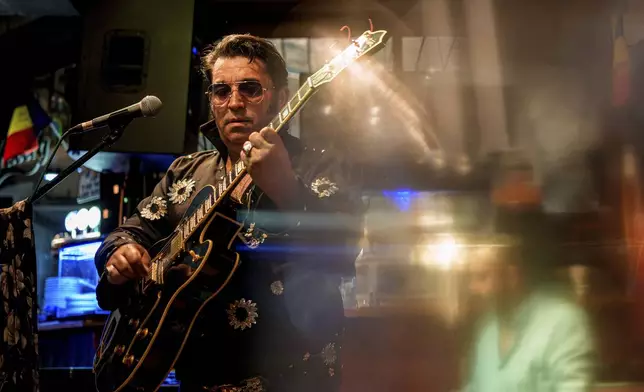 Tudor Lakatos, who goes by the stage name Elvis Rromano, performs with the Taraful Frunzelor band at the Terasa Florilor restaurant, in Bucharest, Romania, Friday, June 20, 2025. (AP Photo/Andreea Alexandru)