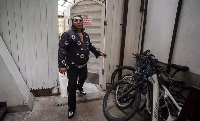 Tudor Lakatos, who goes by the stage name Elvis Rromano, walks to the stage before a performance at the Terasa Florilor restaurant in Bucharest, Romania, Friday, June 20, 2025. (AP Photo/Vadim Ghirda)