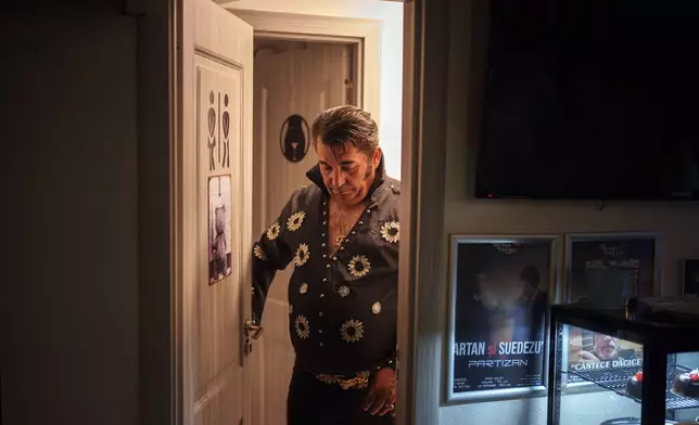 Tudor Lakatos, who goes by the stage name Elvis Rromano, exits the restroom during a break in his performance at the Terasa Florilor restaurant in Bucharest, Romania, Friday, June 20, 2025. (AP Photo/Vadim Ghirda)