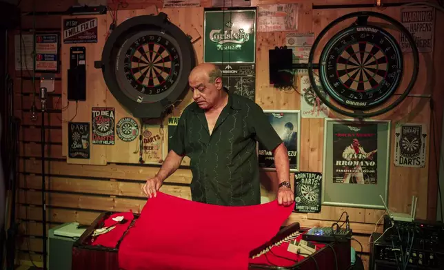 Nicolae Feraru, of the Taraful Frunzelor band covers the cimbalom during a break in the performance of Tudor Lakatos, who goes by the stage name Elvis Rromano at the Terasa Florilor restaurant, in Bucharest, Romania, Friday, June 20, 2025. (AP Photo/Vadim Ghirda)