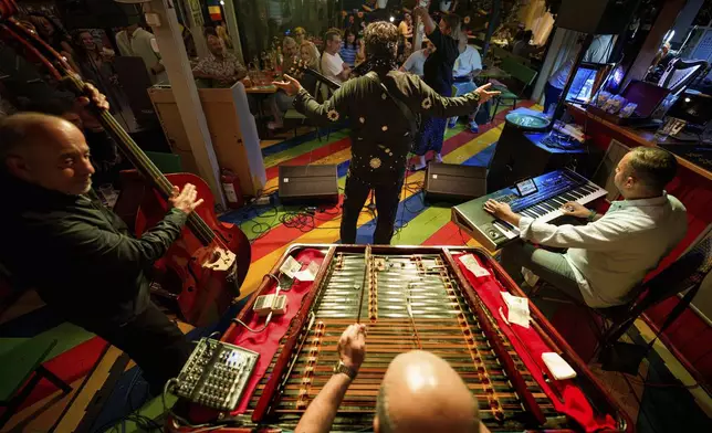 Tudor Lakatos, who goes by the stage name Elvis Rromano, performs at the Terasa Florilor restaurant with the Taraful Frunzelor band, in Bucharest, Romania, Friday, June 20, 2025. (AP Photo/Andreea Alexandru)