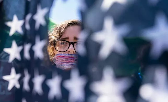 FILE - Emma Rousseau of Oakland, N.J., her mouth bound with a red, white and blue netting, attends a rally on the Fourth of July to protest for abortion rights, at Lafayette Park in front of the White House in Washington, July 4, 2022. (AP Photo/Andrew Harnik, File)