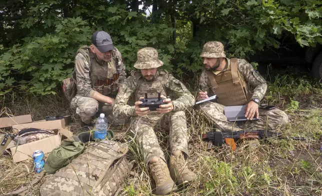 Ukrainian servicemen of 57th motorised brigade control an FPV drone at the frontline in Kharkiv region, Ukraine Tuesday, Aug. 12, 2025. (AP Photo/Andrii Marienko)