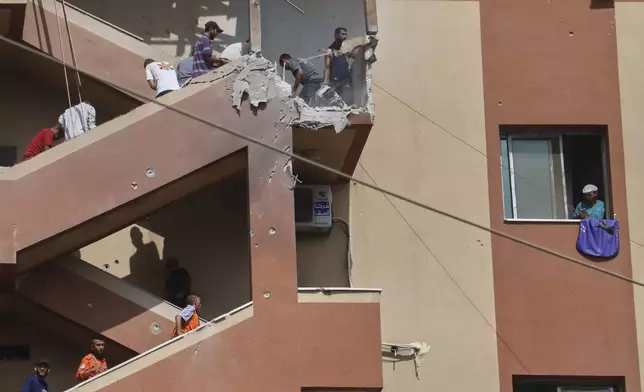 People walk up the stairs to the site of an Israeli strike, minutes before a second strike hit the same spot, killing at least 22 people in total, including five journalists, at Nasser Hospital in Khan Younis, southern Gaza Strip, Monday, Aug. 25, 2025. This was one of the last photos taken by journalist Mariam Dagga, who freelanced for The Associated Press and other outlets, before she walked to the site and was killed in the second strike. (AP Photo/Mariam Dagga)