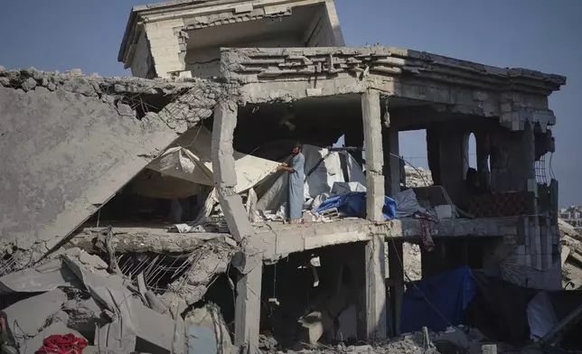 People inspect the damage at the Sheikh Radwan al-Taba UNRWA clinic following an Israeli army bombardment in Gaza City Wednesday, Aug. 6, 2025. The clinic had been evacuated of displaced Palestinians prior to the strike. (AP Photo/Jehad Alshrafi)