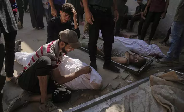 Palestinians mourn their relatives who were killed while trying to reach aid trucks entering northern Gaza Strip through the Zikim crossing with Israel, at Shifa Hospital in Gaza City, Wednesday, Aug. 6, 2025. (AP Photo/Jehad Alshrafi)
