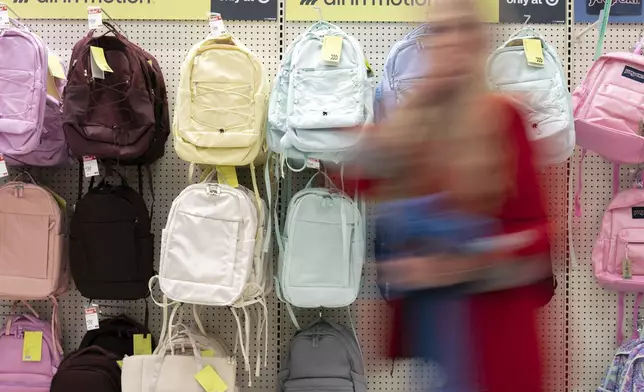 A person walks by backpacks displayed for sale in the back-to-school supplies section of a Target in Sherwood, Ore., Friday, Aug. 8, 2025. (AP Photo/Jenny Kane)