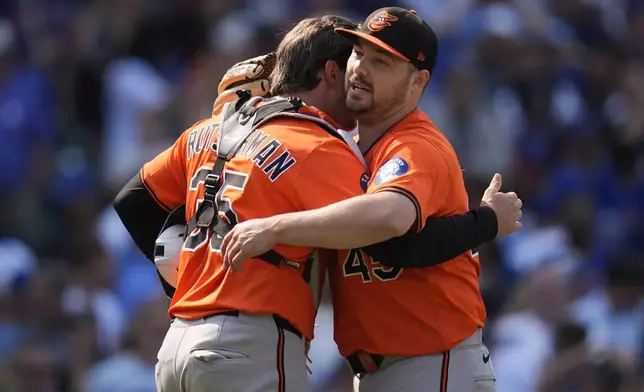 Baltimore Orioles catcher Adley Rutschman (35), left, and pitcher Keegan Akin (45) celebrate their team's win over the Chicago Cubs in a baseball game Saturday, Aug. 2, 2025, in Chicago. (AP Photo/Erin Hooley)