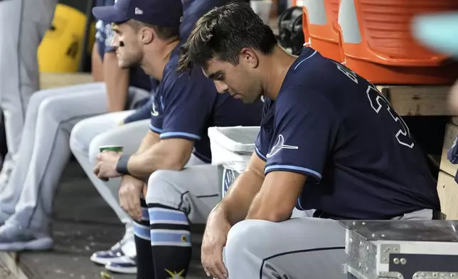 Tampa Bay Rays starting pitcher Joe Boyle, right, sits in the dugout after being pulled from a baseball game against the Seattle Mariners during the fourth inning, Saturday, Aug. 9, 2025, in Seattle. (AP Photo/Ted S. Warren)