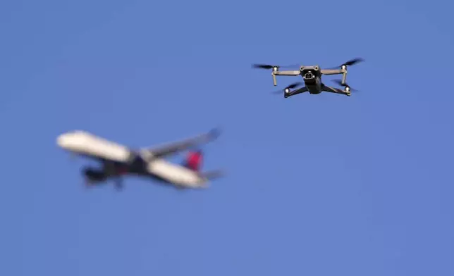 FILE - A drone hovers in airspace outside the safety perimeter surrounding St. Louis Lambert International Airport as an airliner approaches for a landing on March 10, 2025. (AP Photo/Jeff Roberson, File)