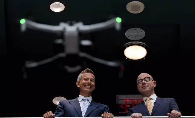 Transportation Secretary Sean Duffy, left, and Federal Aviation Administration administrator Bryan Bedford, right, watch a drone flight demonstration following a news conference on new drone regulations, Tuesday, Aug. 5, 2025, in the atrium of the Department of Transportation in Washington. (AP Photo/Julia Demaree Nikhinson)