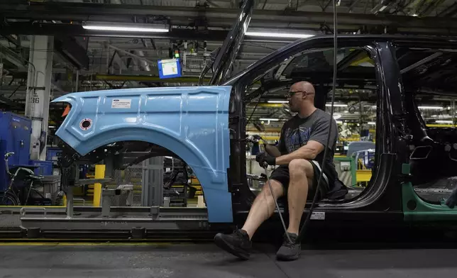 FILE - A vehicle assembly technician works on a 2025 Ford Expedition during a media tour to launch the 2025 Ford Expedition at the Ford Motor Company Kentucky Truck Plant, April 30, 2025, in Louisville, Ky. (AP Photo/Carolyn Kaster, file)