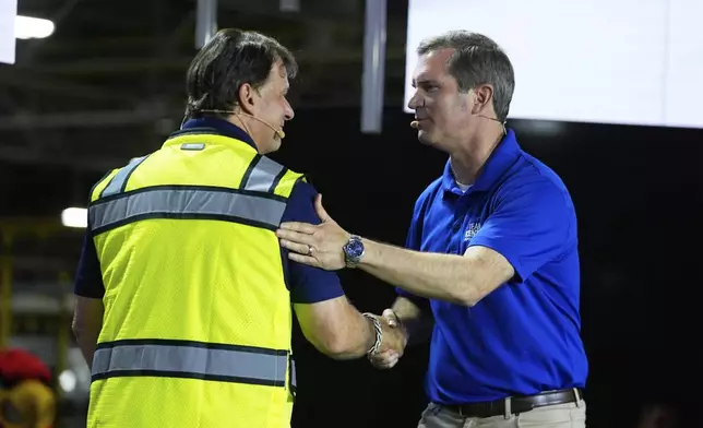 Ford CEO Jim Farley, left, shakes hands with Kentucky Governor Andy Beshear at the Louisville Assembly Plant, Monday, Aug. 11, 2025, in Louisville, Ky. (AP Photo/Darron Cummings)