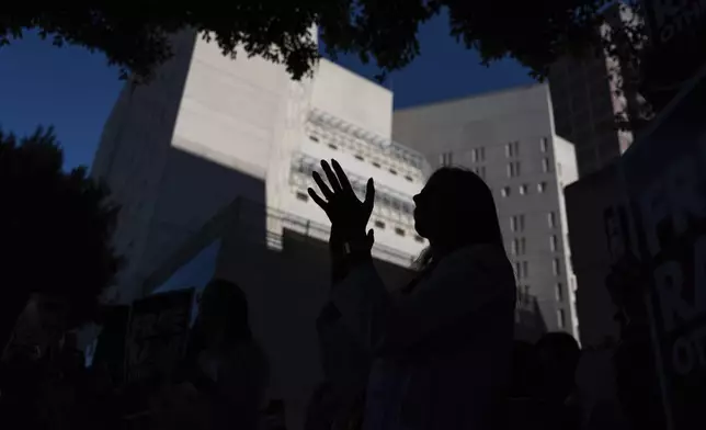 Dr. Wafaa Alrashid, whose husband, Rami Othmane, a Tunisian musician, is detained at the U.S. Immigration and Customs Enforcement facility, watches musicians perform during a rally outside the facility in Los Angeles Friday, July 25, 2025. (AP Photo/Jae C. Hong)
