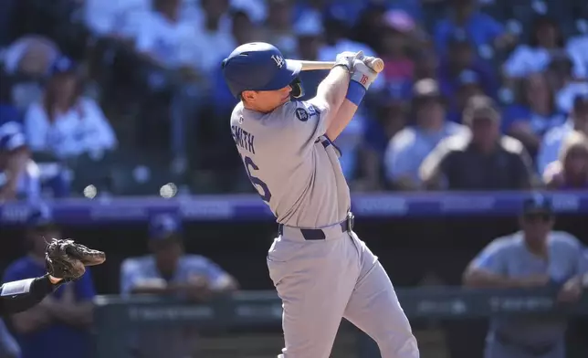 Los Angeles Dodgers' Will Smith singles to drive in a run off Colorado Rockies relief pitcher Luis Peralta in the eighth inning of a baseball game Thursday, Aug. 21, 2025, in Denver. (AP Photo/David Zalubowski)