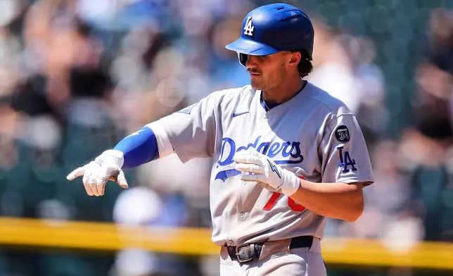 Los Angeles Dodgers' Alex Freeland gestures after hitting a double to drive in a run off Colorado Rockies starting pitcher Chase Dollander in the fourth inning of a baseball game Thursday, Aug. 21, 2025, in Denver. (AP Photo/David Zalubowski)
